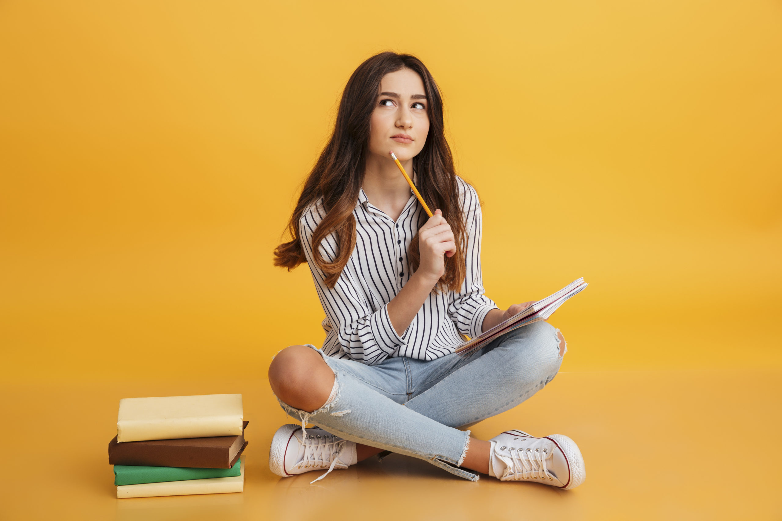 Portrait of a pensive young girl making notes